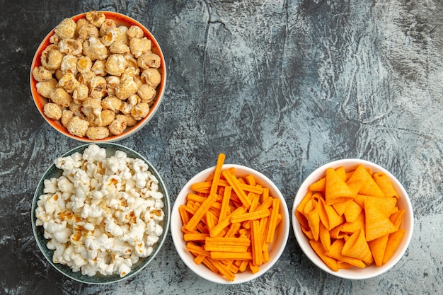 Top view different snacks popcorn rusks and cips on light surface