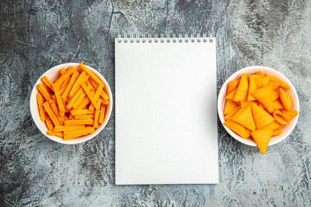 Top view different snacks rusks and cheese cips on light surface