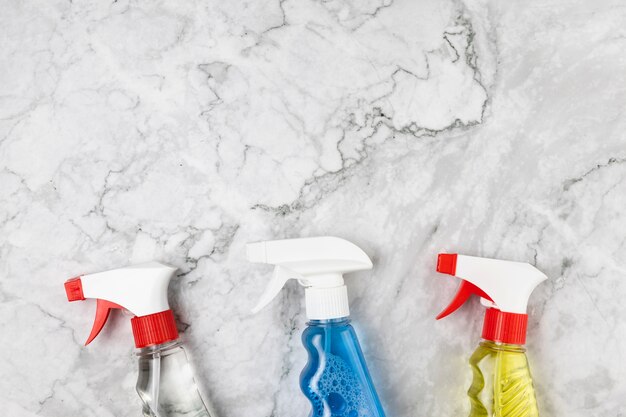 Top view different spray bottles on marble table