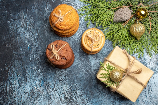 Vista dall'alto diversi biscotti dolci con regalo sullo sfondo chiaro