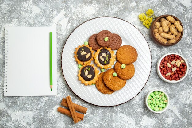 Top view different sweet cookies with nuts on the white surface