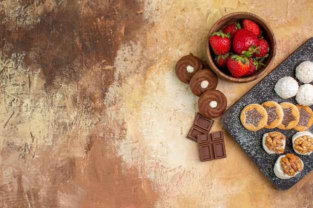 Top view different sweets with cookies and fruits on a light desk