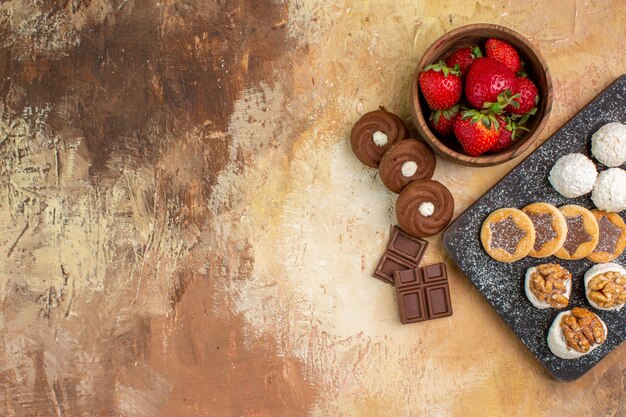 Top view different sweets with cookies and fruits on a light desk