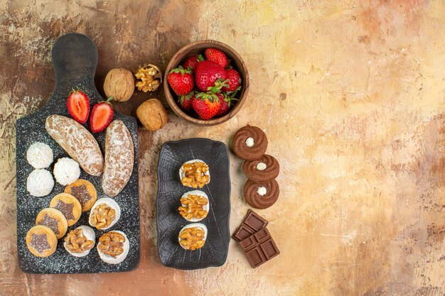 Top view different sweets with cookies and fruits on light desk