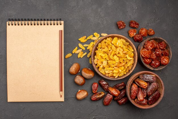 Top view of different tasty raisins from grape and other fruits on a grey surface