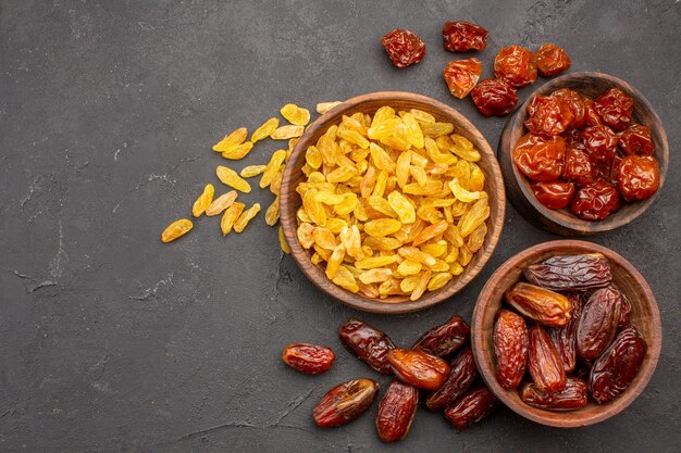 Top view of different tasty raisins from grape and other fruits on grey surface