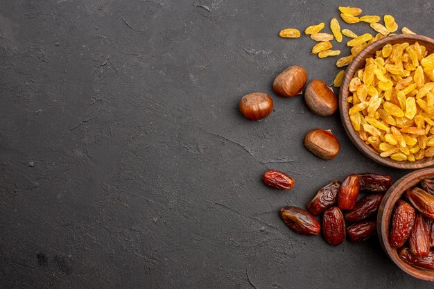 Top view of different tasty raisins from grape and other fruits on the grey surface