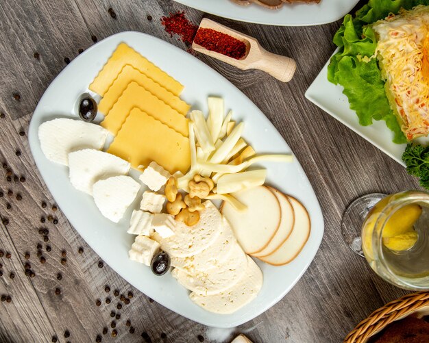 테이블에 하얀 접시에 치즈의 다른 유형의 상위 뷰