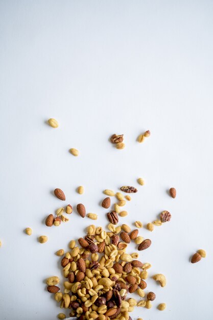 Top view of different types of nuts on a white surface