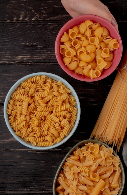 Top view of different types of pasta on wooden surface