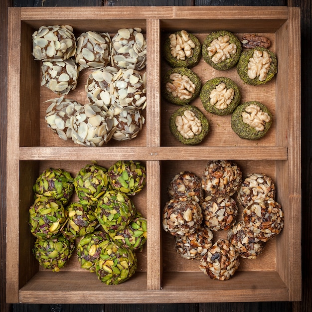 Top view different types of pistachio cookies in wooden box .