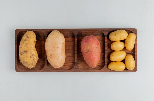 Вид сверху разных видов картофеля на белой поверхности