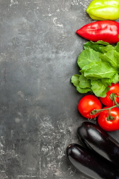 灰色の背景にさまざまな野菜、トマト、ピーマン、ナスの上面図