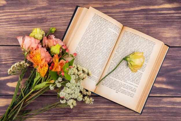 Top view of different wonderful and colorful flowers with yellow rose on wood