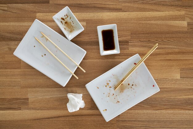 Top view dirty plates and chopsticks on table