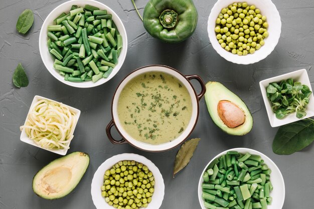 Top view of dishes with green peas and avocado