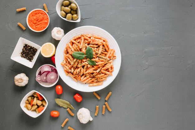 Top view of dishes with pasta and pepper