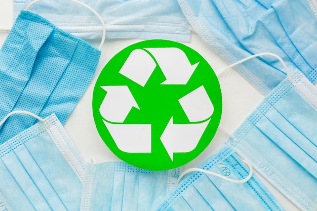 Top view disposable medical masks and recycle symbol