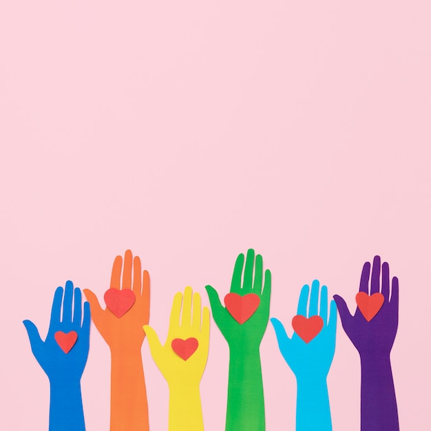 Free photo top view diversity composition of different colored paper hands with copy space