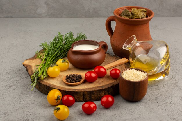 top view dolma with yogurt olive oil and tomatoes on the grey