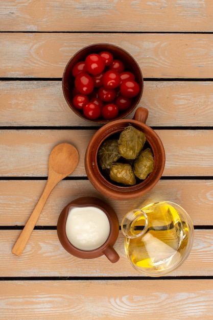 Vista dall'alto dolma con yogurt olio d'oliva e pomodori sul legno