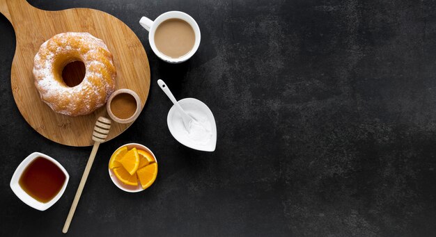 Top view of donut on chopping board with honey and coffee