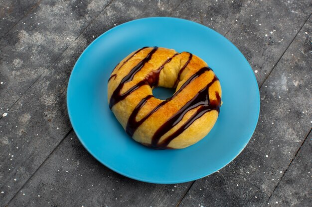 top view donut sweet delicious yummy with chocolate inside blue palte on the grey floor