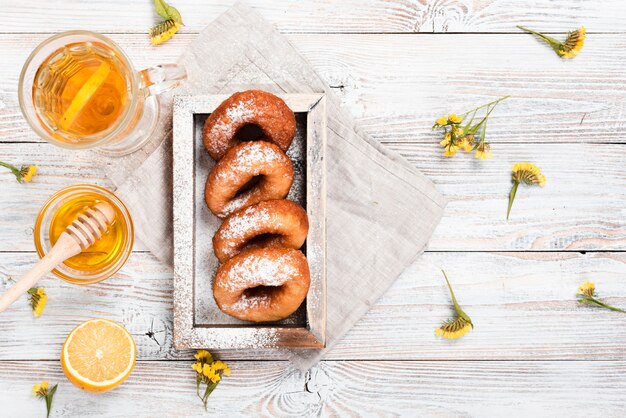 Top view of donuts with tea and honey