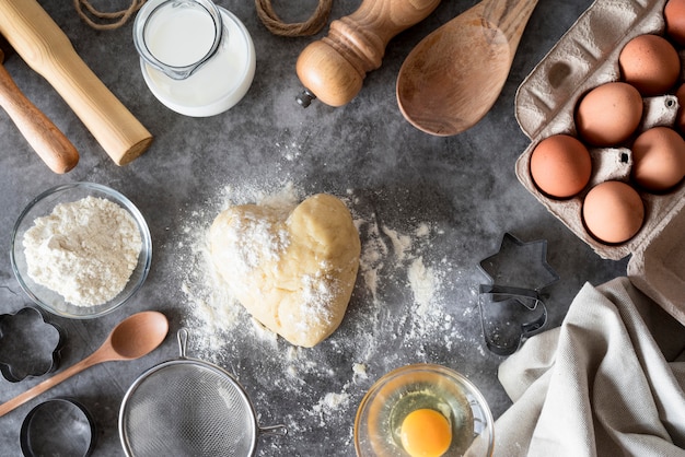 Top view dough on counter with flour and eggs