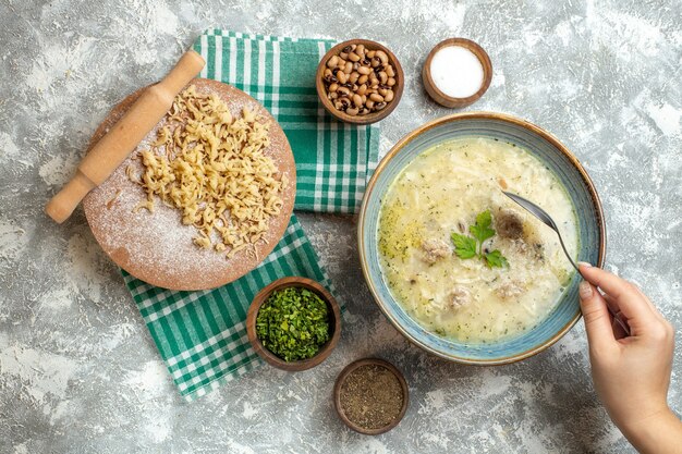 Top view dough and rolling-pin on dough board on tablecloth on grey background