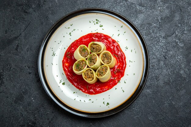 Top view dough with meat sliced dough slices with tomato sauce on grey space