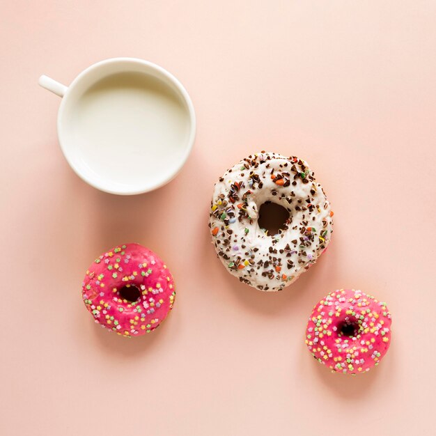 Top view of doughnuts with sprinkles and milk