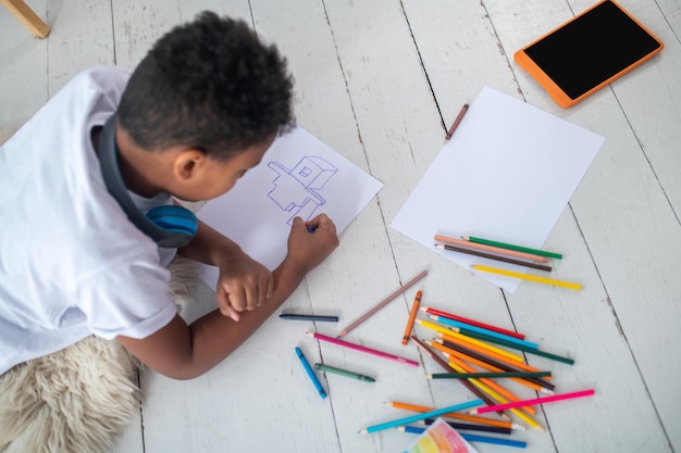 Top view of drawing boy lying on floor