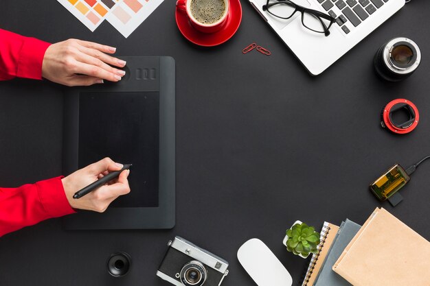 Top view of drawing pad with hands on desk