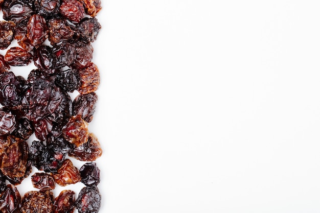 Free photo top view of dried cherries on white background with copy space