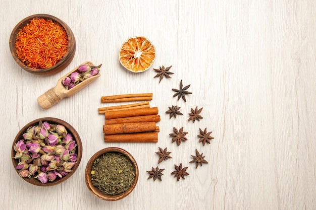 Top view dried flowers with cinnamon on white desk color flower flavor