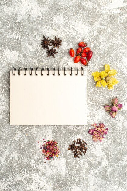 Top view dried flowers with notepad on white background flower plant dust flavor