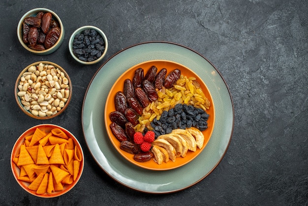 Top view dried fruits with different raisins on dark-grey space