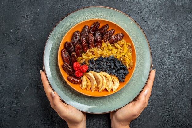 Top view dried fruits with different raisins and snacks on grey space