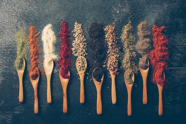 Top view dried herbs in spoons