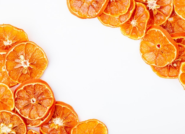 Top view of dried orange slices arranged on white background with copy space