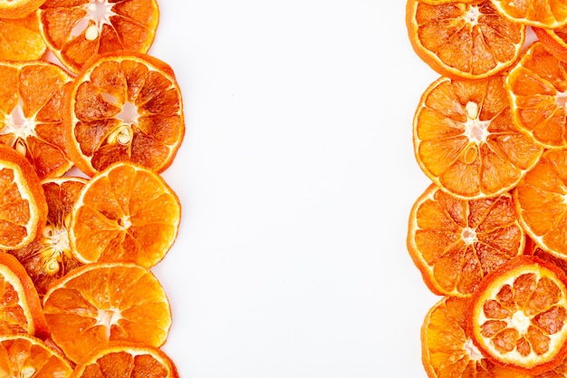 Top view of dried orange slices arranged on white background with copy space