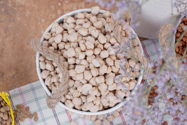 Top view of dried peas in buckets with flowers.