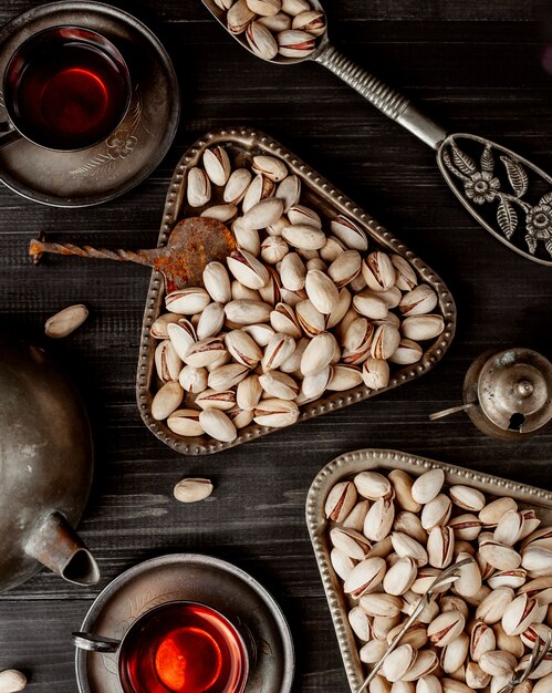 Top view of dried pistachios in vintage metal servings