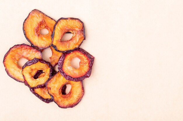 Top view of dried plum slices isolated on brown paper texture background with copy space