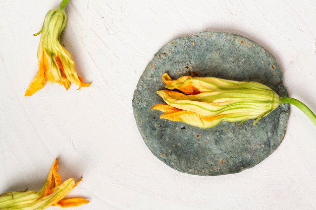 Foto gratuita fiore di zucca essiccato vista dall'alto con tortilla di spinaci