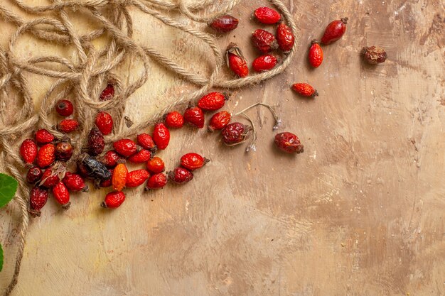 Top view dried red berries with ropes on wooden desk red fruit berry