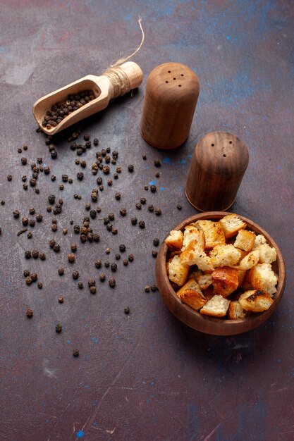 Top view dried rusks with pepper on dark desk