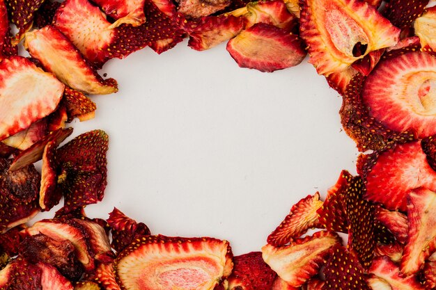 Top view of dried strawberry slices arranged on white background with copy space