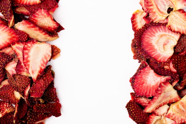 Top view of dried strawberry slices arranged on white background with copy space